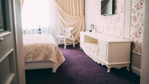トムスクにあるHotel Montanaのベッドルーム1室(ベッド1台、ドレッサー、椅子付)