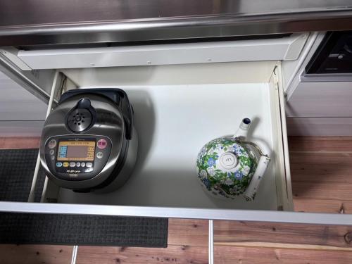a cell phone and a clock in a drawer at Oyado Ichi - Vacation STAY 33546v in Ise