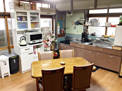 a kitchen with a wooden table and chairs in a kitchen at Tokami House - Vacation STAY 21218v in Yasugi