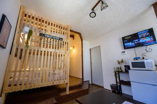 a living room with a wooden gate and a television at Hyuga Surf Camp 211 - Vacation STAY 35435v in Hyuga