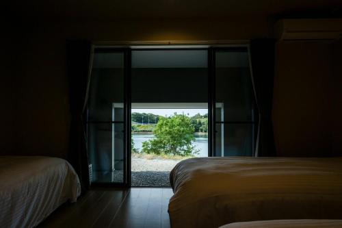a room with two beds and a large glass door at Seaside Villa N - Vacation STAY 21976v in Mitsugoe