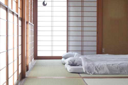 a bed sitting in a room with windows at Dekopin House - Vacation STAY 18550 in Hanamaki