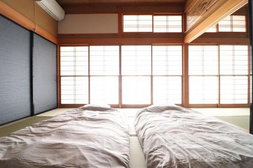 a large bed in a room with large windows at Dekopin House - Vacation STAY 18550 in Hanamaki