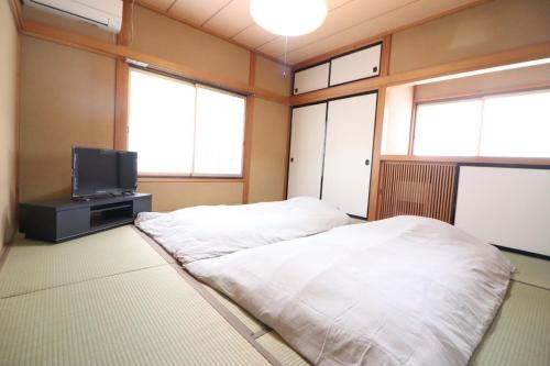 a room with two beds and a tv at Dekopin House - Vacation STAY 18550 in Hanamaki