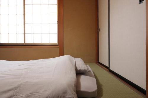 a bedroom with a white bed and a window at Dekopin House - Vacation STAY 18550 in Hanamaki