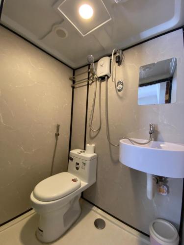 a bathroom with a toilet and a sink at Moalboal Beach Front Hotel in Moalboal