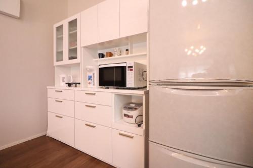 a kitchen with a refrigerator and a microwave at Dekopin House - Vacation STAY 18550 in Hanamaki