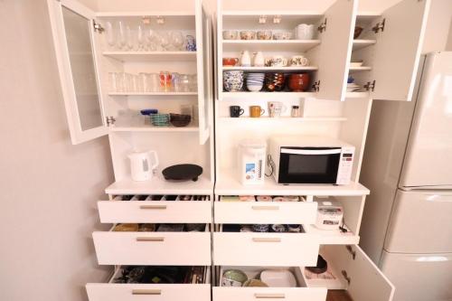 a kitchen with white cabinets and a refrigerator at Dekopin House - Vacation STAY 18550 in Hanamaki