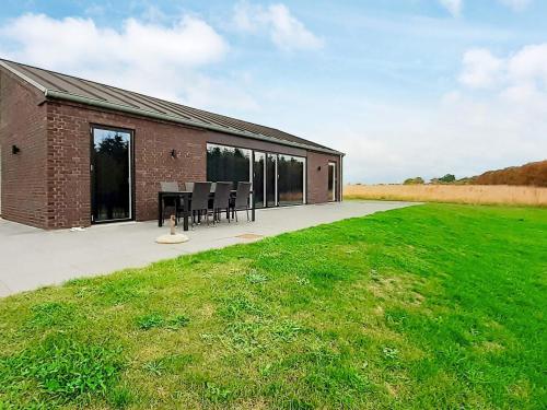 a brick building with a table and chairs in a field at 6 person holiday home in Slagelse in Slagelse