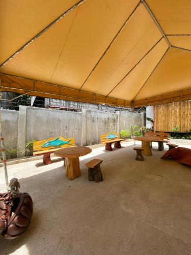 a group of tables and benches in a tent at Moalboal Beach Front Hotel in Moalboal