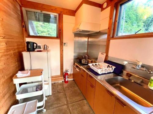 a small kitchen with a sink and a refrigerator at Gubo Satoyama Suite Lodge & Camp - Vacation STAY 39507v in Katsuura