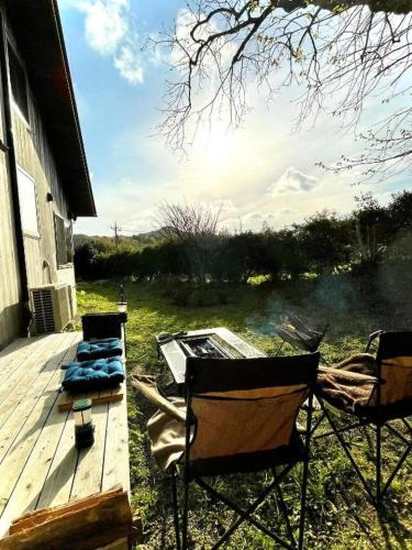 two chairs and a table on a deck next to a house at Gubo Satoyama Suite Lodge & Camp - Vacation STAY 39504v in Katsuura