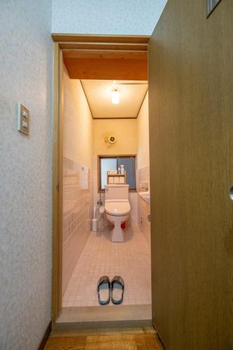 a bathroom with a toilet and a pair of shoes at Kominka COCONE - Vacation STAY 18597 in Hashima
