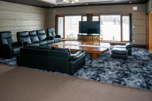 a living room with black leather furniture and a tv at Gold lich - Vacation STAY 18602 in Kamikawa