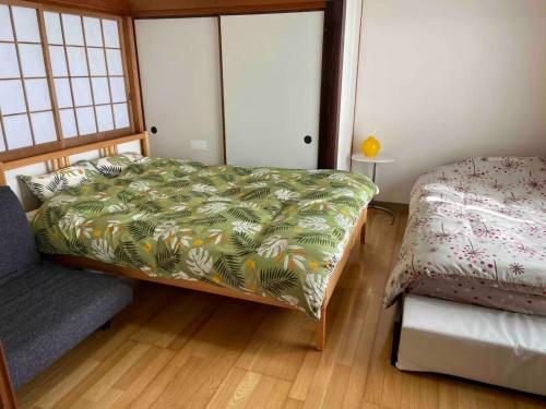 a bedroom with a bed and a couch in it at Guest House Wakamizu - Vacation STAY 18625 in Koga