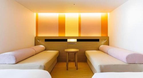 a room with two beds and a stool in it at Hotel Dream Gate Maihama in Chiba
