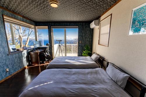 - 2 lits dans une chambre avec vue sur les montagnes dans l'établissement AZUR Izu Atagawa aurora - Vacation STAY 31844v, à Okawa