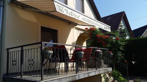 a balcony of a restaurant with flowers on it at FaDóra Apartman in Tihany