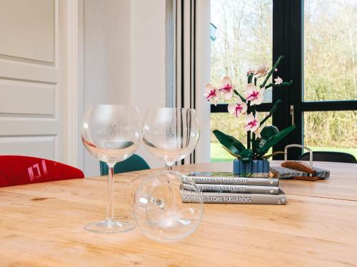 two wine glasses sitting on top of a wooden table at 8 person holiday home in Ansager-By Traum in Ansager