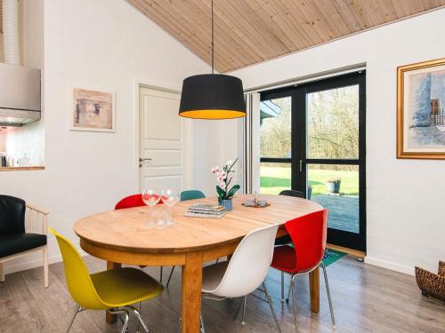 a dining room with a wooden table and colorful chairs at 8 person holiday home in Ansager-By Traum in Ansager