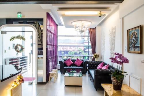 a living room with a black couch and pink pillows at Jinye B&B 金夜民宿 in Xiaoliuqiu