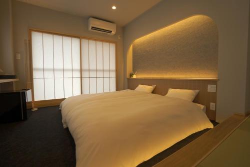 a bedroom with a large white bed and a window at Mitsuka Building - Vacation STAY 43030v in Kofu