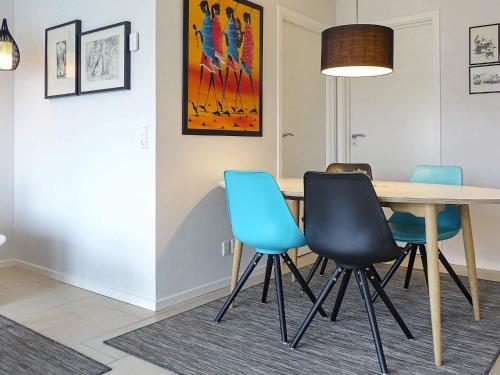 a dining room with a table and blue chairs at 4 person holiday home in Bogense-By Traum in Bogense