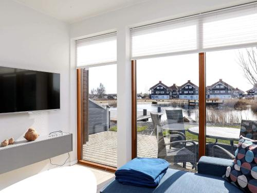 a living room with a large window with a television at 4 person holiday home in Bogense-By Traum in Bogense