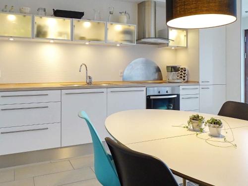 a white kitchen with a table and chairs at 4 person holiday home in Bogense-By Traum in Bogense