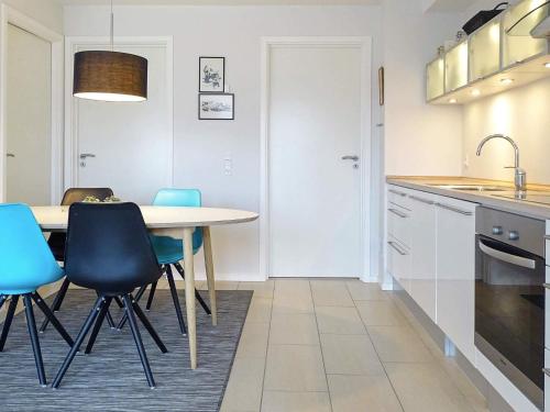 a kitchen with a table and some blue chairs at 4 person holiday home in Bogense-By Traum in Bogense