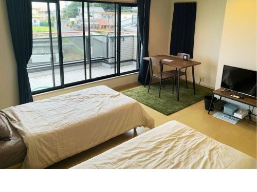 pokój z dwoma łóżkami, biurkiem i telewizorem w obiekcie Gardens Mihama - Vacation STAY 46935v w mieście Wada