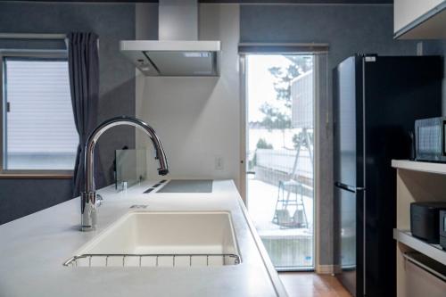 una cucina con lavello e frigorifero di THE GRACIOUS - Vacation STAY 18633 a Sapporo