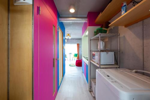 eine Küche mit einer rosa und bunten Wand in der Unterkunft Stayloopスカイツリー in Tokio