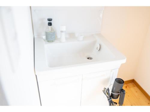 a white bathroom sink with a bottle of soap on it at HOSTEL ALA - Vacation STAY 52536v in Tsunō