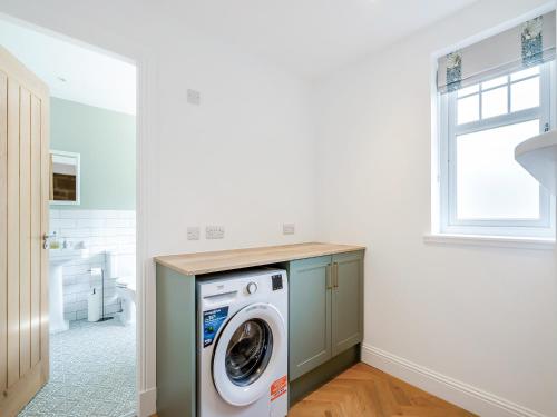 eine Waschküche mit Waschmaschine und Trockner in der Unterkunft Gardener's Cottage in Clunie