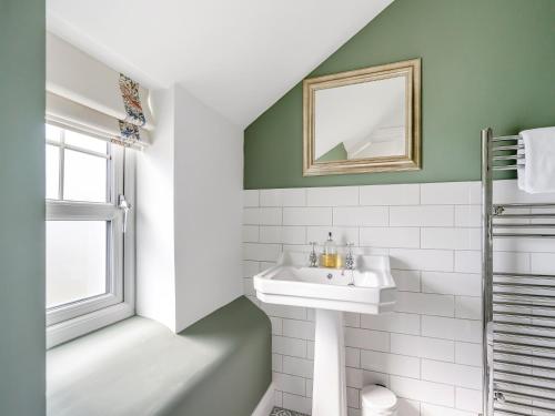 ein Badezimmer mit Waschbecken und Spiegel in der Unterkunft Gardener's Cottage in Clunie