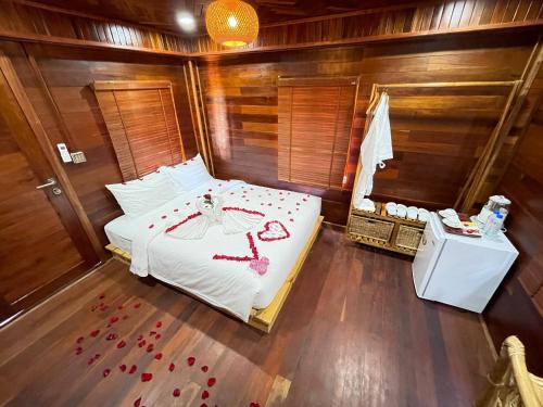 a bedroom with a bed with red rose petals on it at Vvillage 
