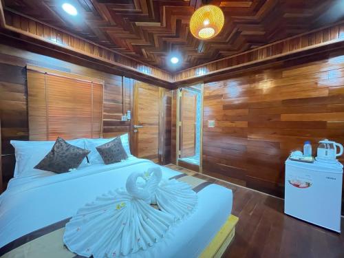 a bedroom with a large white bed with wooden walls at Vvillage 