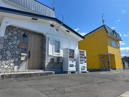 a yellow and white building with a door at Minpaku Dorihu - Vacation STAY 18675 in Taiki