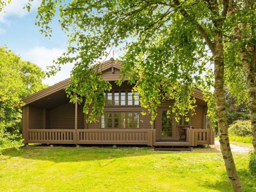 a log home with a porch and a yard at 4 star holiday home in Ringkøbing in Ringkøbing