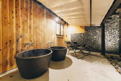 a large bath tub in a room with wooden walls at moon river - Vacation STAY 53517v in Hatsukaichi