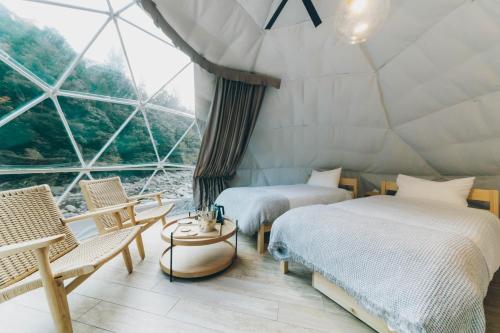 two beds in a room with a large window at moon river - Vacation STAY 53517v in Hatsukaichi