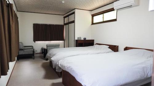 a bedroom with two beds and a chair and a window at Izunuma Lake Hill Tenjo - Vacation STAY 59016v in Tome
