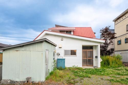 a white house with a red roof at AKATSUKI - Vacation STAY 18831 in Kami-furano