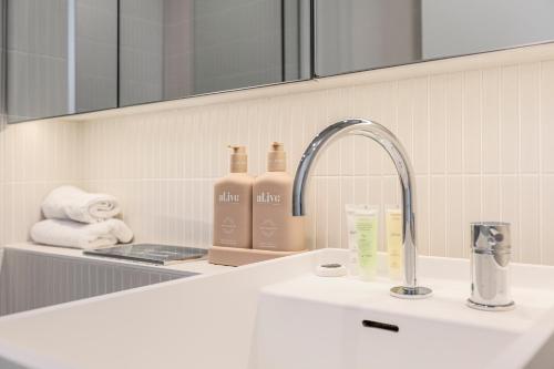 a bathroom counter with a sink and a faucet at Matilda's Skyview - Luxe 2BR, 2BA Near Crown in Melbourne
