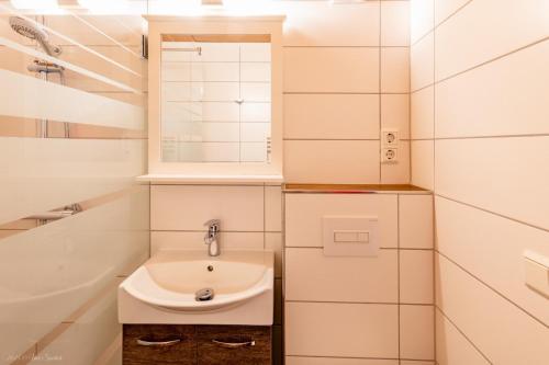 a bathroom with a sink and a mirror and a tub at Ferienhaus Vier Jahreszeiten in Frauenwald