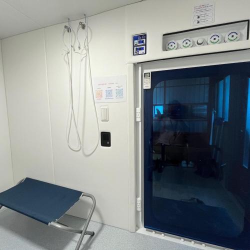 a room with a door in a hospital with a chair at Fujiminchi Inn - Vacation STAY 65731v in Fujimi