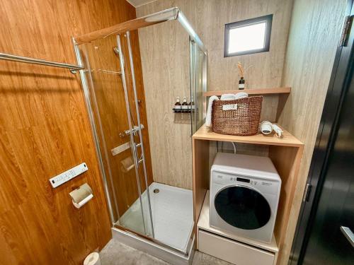 a small bathroom with a shower and a washing machine at Canggu Irab - Vacation STAY 66913v in Sarahama