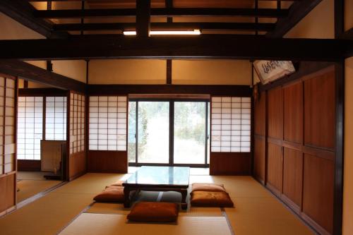 a room with a table and a couch and windows at Old-style house for rent in Ariyama - Vacation STAY 67911v in Nakatsugawa