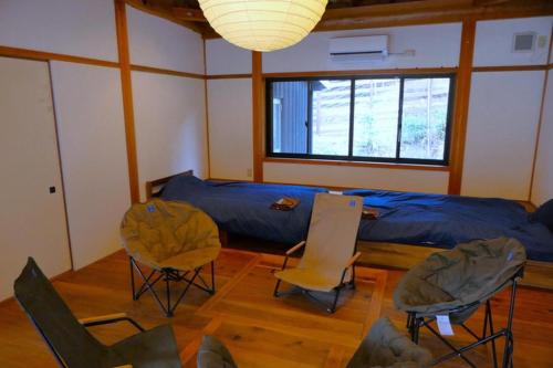 a room with a bed and chairs in it at Camping-style accommodation: Yumeraku - Vacation STAY 65716v in Ema